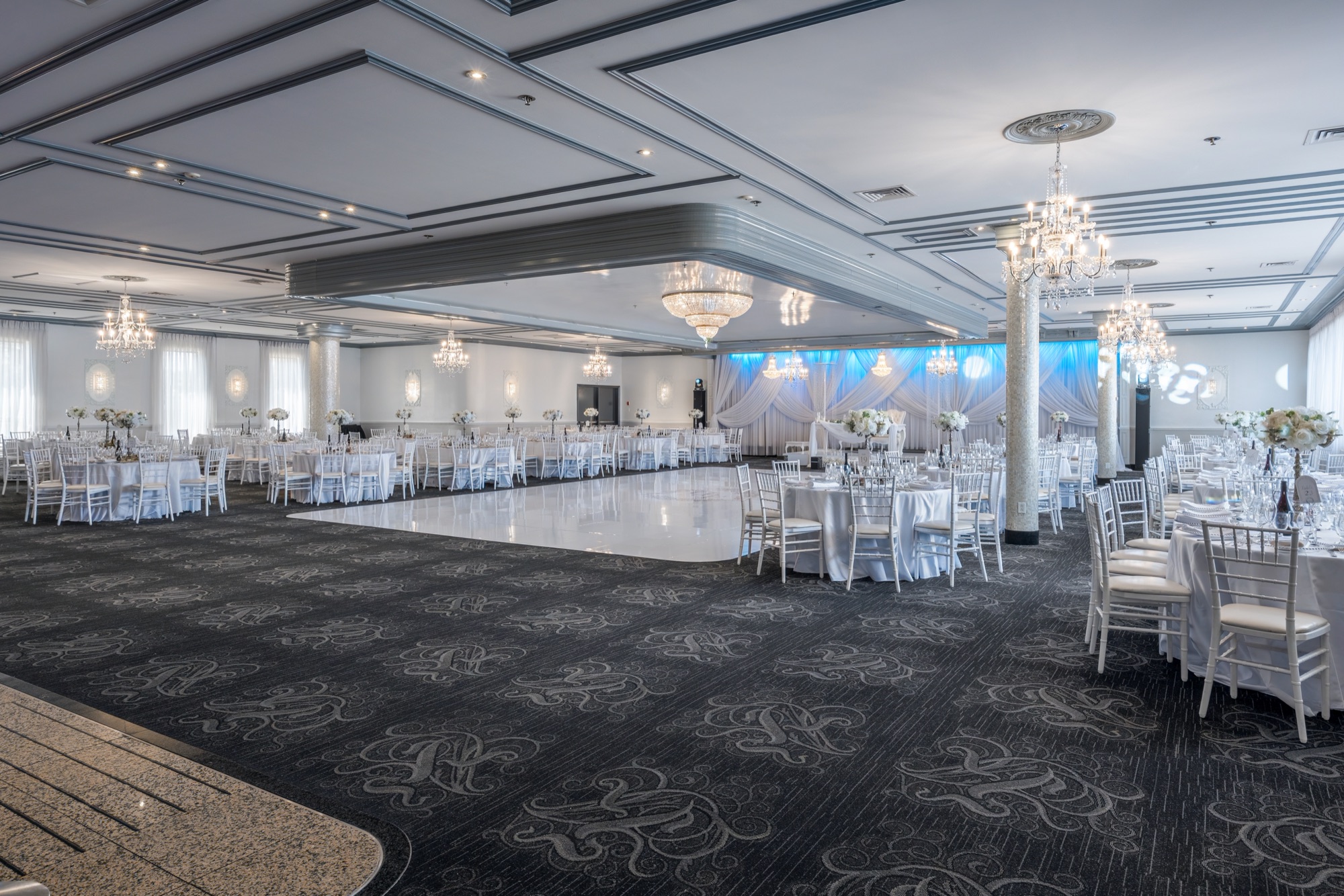 Grande salle avec piste de danse et tables blanches